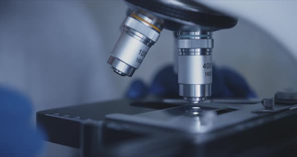 Sample Slide and Microscope with Metal Lens at Laboratory. alt