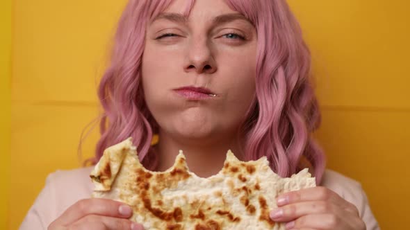 Close Shot of Funny Happy Hungry Positive Girl Eating Pita Bread with Cheese Filling on a Yellow