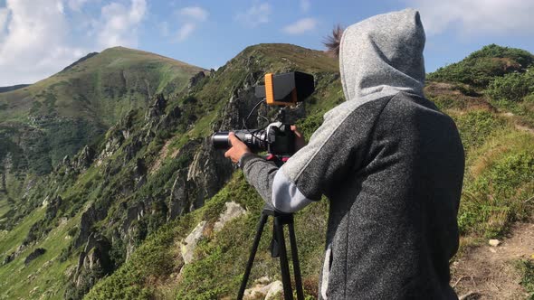 Backview Cameraman Filming Beautiful Landscape of Mountains alt