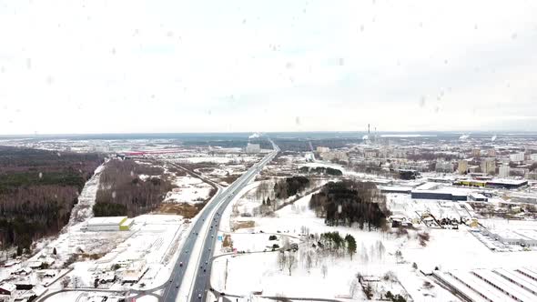 Kaunas city and A1 highway during heavy snowfall in winter season, aerial drone view alt