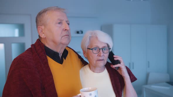 Elderly Couple Hugging and Speaking on the Phone While Watching Tv alt