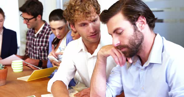 Group of business executives interacting with each other alt