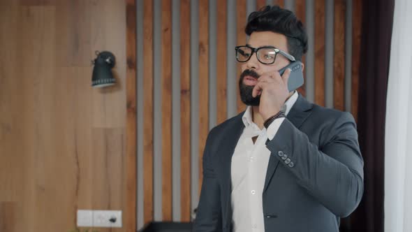 Ambitious Middle Eastern Businessman Making Mobile Call From Hotel Room alt