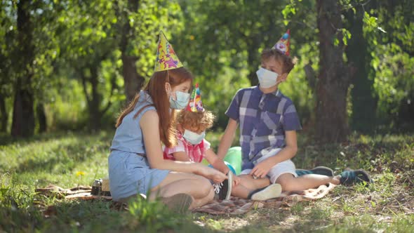 Side View Caucasian Redhead Teenage Girl in Covid Face Mask Talking Sitting with Friends Siblings on alt