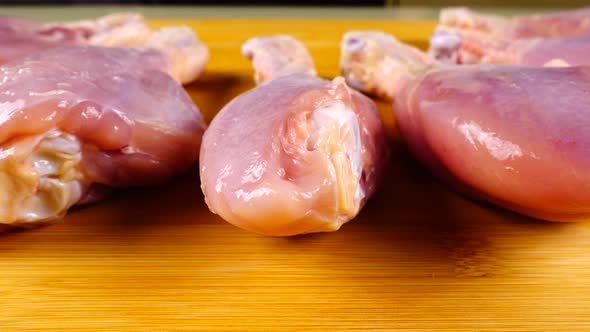 Fresh chicken legs are laid out on a cutting board. alt