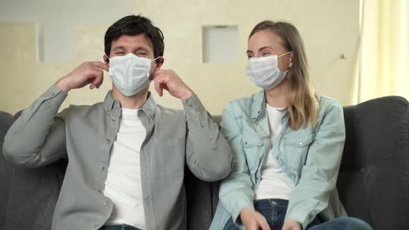 The Covid-19 Virus Epidemic Ends, a Woman and a Man Sitting on a Sofa at Home Take Off Their alt