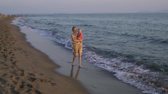 Mother Walks with Her Daughter Along the Coast of the Sea