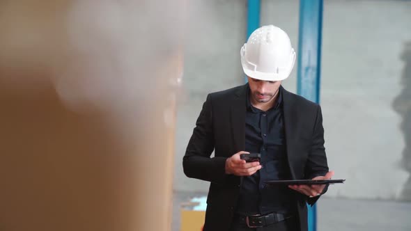 Factory Manager Using Tablet Computer in Warehouse or Factory alt
