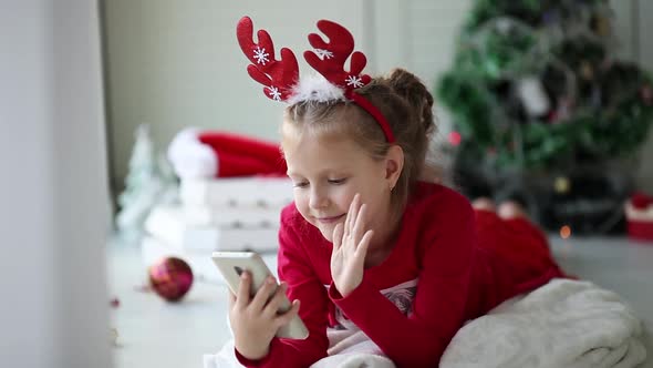 A little girl wishes a Happy New Year using a mobile phone for video calls
