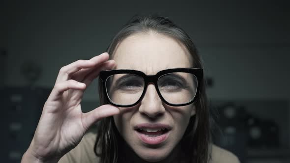 Woman with eyesight problems adjusting glasses