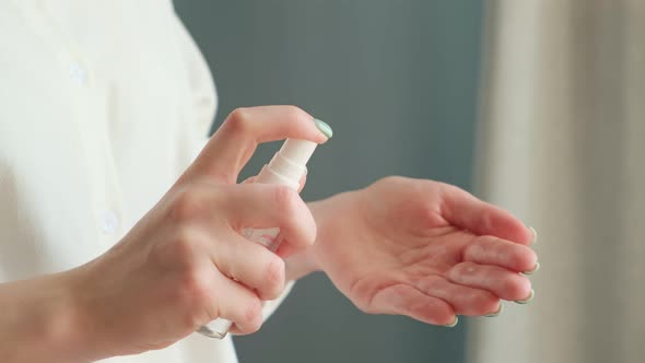 Woman hands using antiseptic spray. COVID-19 Pandemic. Protection from bacterias and virus. alt