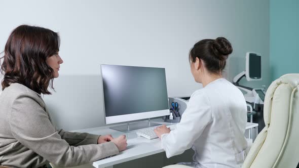 Woman in Suit Talks to Positive Doctor in Hospital Office alt