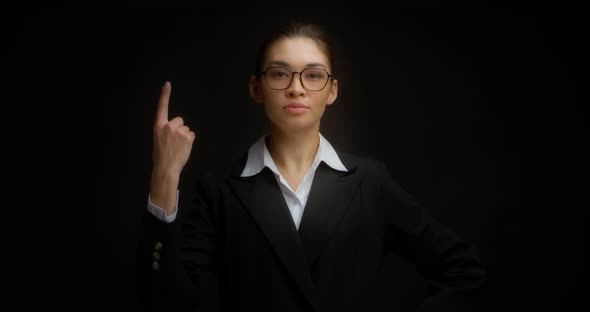 Business Woman with Glasses with a Serious Face Shows One Finger