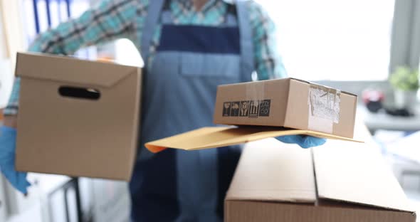 Uniformed Courier Giving Yellow Envelope and Cardboard Box to Customer Closeup  Movie alt