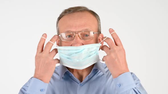 elderly man putting on a medical mask Isolated on a white background