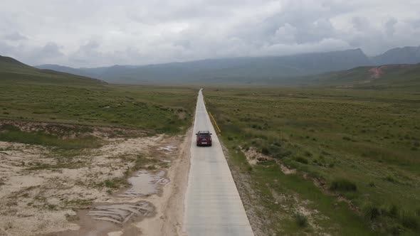 4K Aerial Shot of Car Driving In The Wild