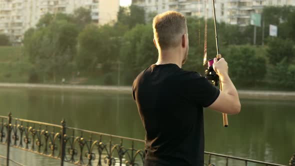 a Fisherman in a Black Tshirt is Fishing in a City Pond alt