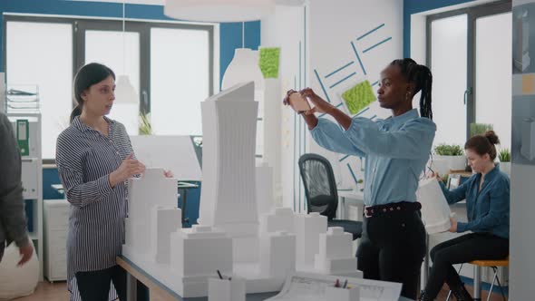 Diverse Team of Women Working on Building Model and Structure with Smartphone alt