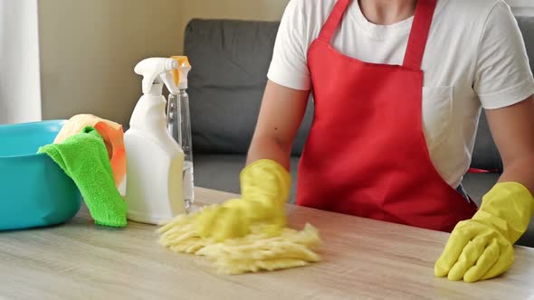 Woman in an Apron and Protective Gloves Washes and Polishes the Countertop Diligently alt