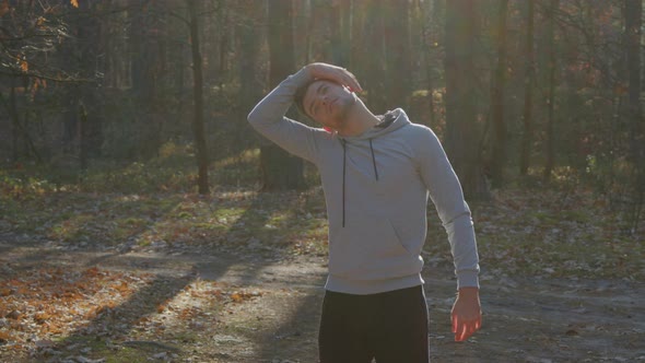 Man Is Stretching In Forest Before Morning Workout
