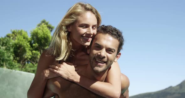 Man carrying woman on piggyback alt