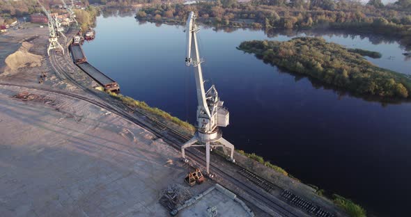 Boom of an Idle Port Crane on the Background of the River at Dawn alt