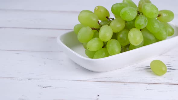 Green Grapes on a White Plate on a White Background Closeup