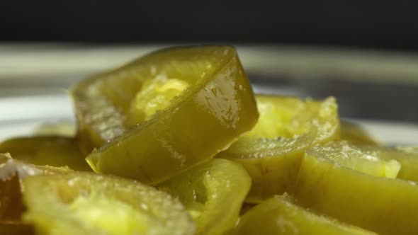 Sliced Pickled Jalapeno Peppers Rotate on the Plate As Background Closeup of Pickled Chili Jalapeno alt