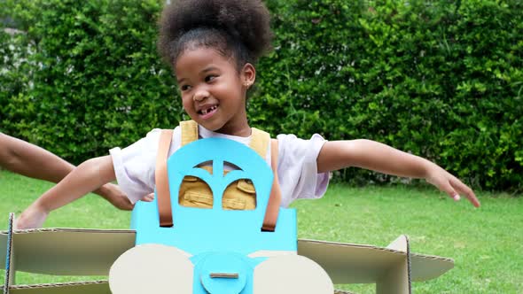 Happy child playing with a toy paper plane in the house. alt