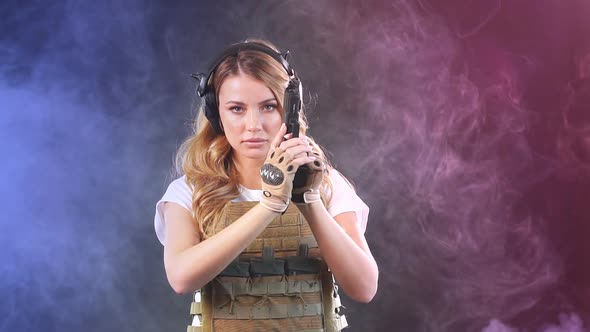 Woman in Protective Armor Holds Gun in Hands alt