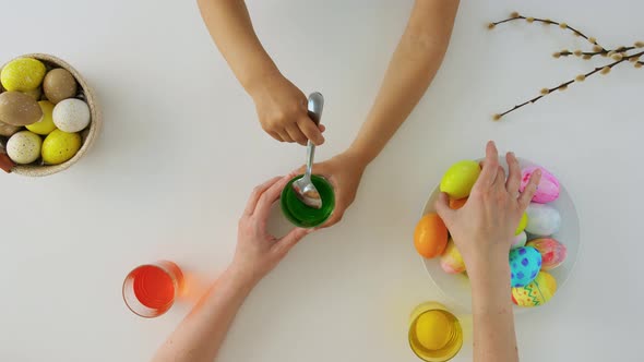 Hands of Child and Parent Dyeing Easter Eggs