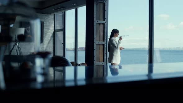 Ceo Woman Enjoying Tea with Ocean Panoramic Window View alt
