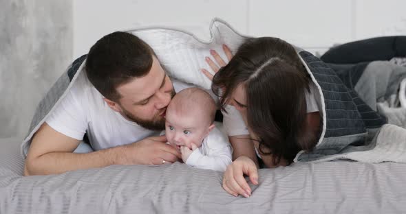 Happy young smiling family play with baby.