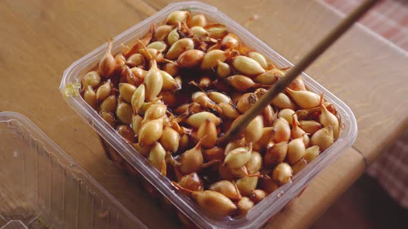 The Process of Soaking the Onion Bulbs in a Solution of Potassium Permanganate alt