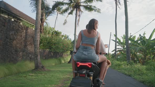 Couple Riding Scooter on Tropical Island alt