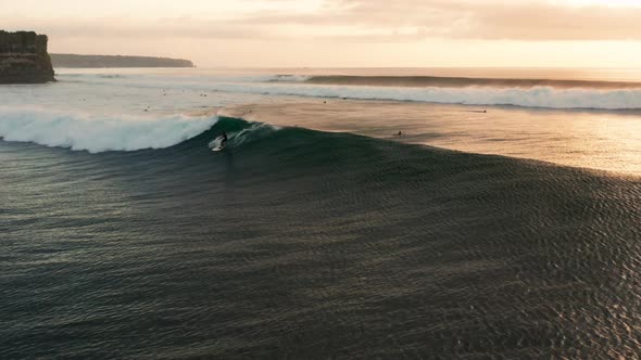 Following large waves at sunset