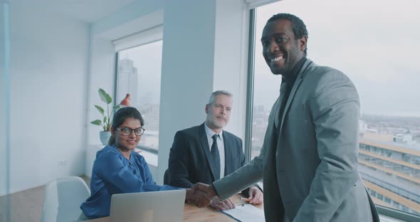 African businessman shake hands with recruiter and smile to the camera alt