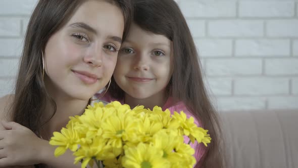 Birthday of the elder sister. Girls with a bouquet of flowers.  alt