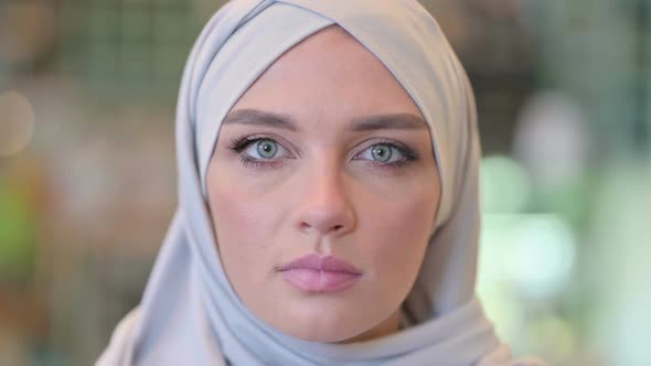 Portrait of Face of Serious Young Arab Woman with Hijab Looking at the Camera alt