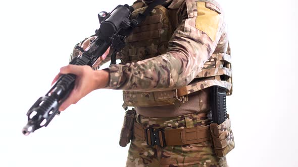 Man in combat camouflage and body armor with an automatic rifle