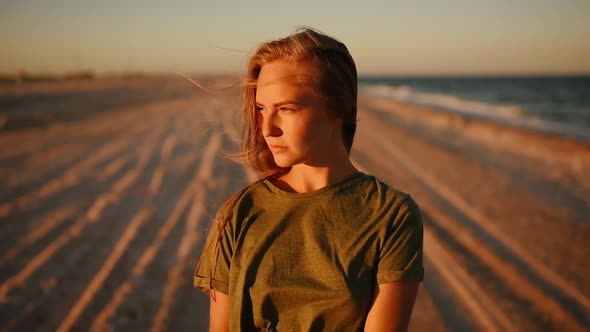 Worried Serious Woman Alone on the Beach Looking at Camera alt