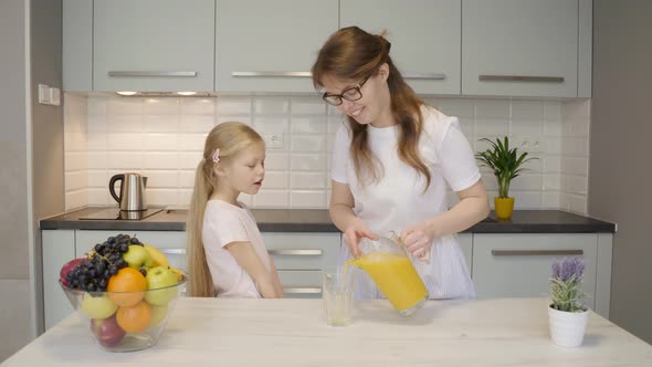 Mother Pouring Juice for Daughter