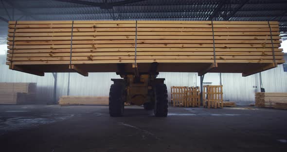 The loader is carrying the floorboards. Warehouse of a woodworking plant.