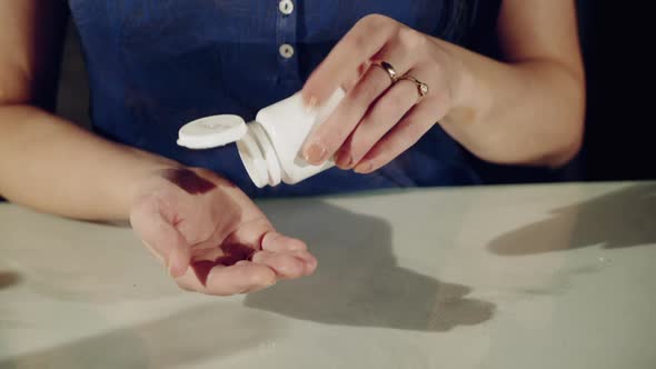 One step from death. Close up of pills in hands of young depressed girl holding them alt