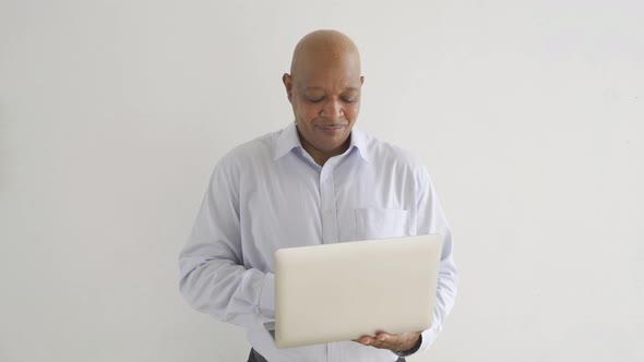 smiling senior old elderly business Black African American man person typing on computer alt