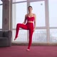 Pretty Brunette Girl with Ponytail Wearing Red Sport Suit Practicing Yoga at Home - VideoHive Item for Sale