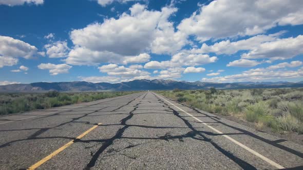 Small Asphalt Road Surrounded By Desert with Clouded Blue Sky. alt