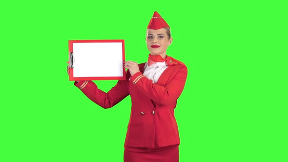 Stewardess Raises a Red Folder with a White Sheet of Paper. Green Screen alt