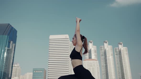 Sport woman wearing wireless headphones and stretching muscles before running in city. alt