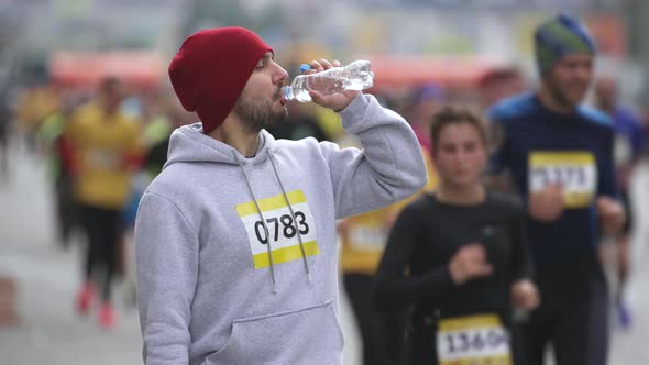 Portrait of Drinking Water and Looking at Camera Sportsman on Marathon Event